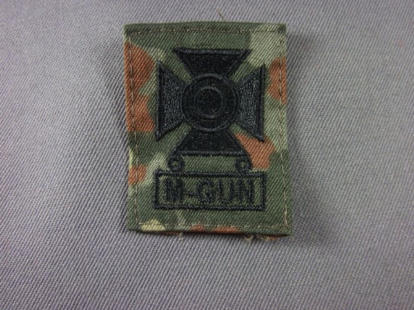 Sharpshooterabzeichen mit Qbar M-Gun, schwarz maschinengestickt auf Flecktarn