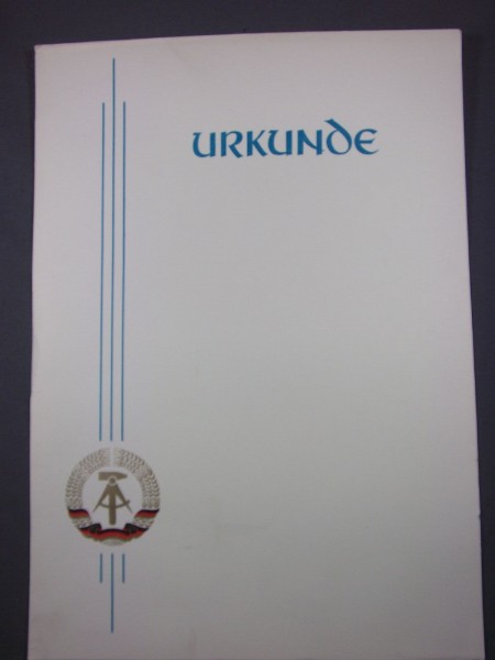 Urkunde blanko Schrift und 3 Linien links sind in Blau das Wappen der DDR ist auch links in den Linien 