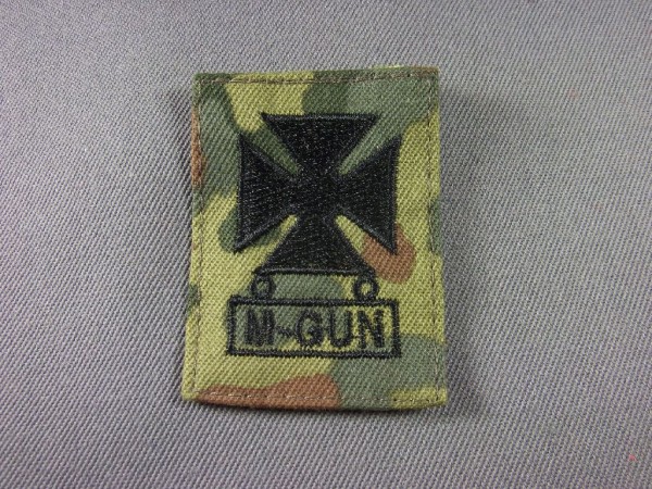 Marksmanabzeichen mit Qbar M-Gun, schwarz maschinengestickt auf Flecktarn