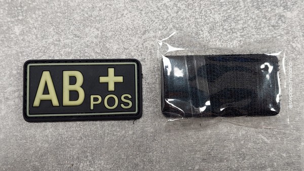 Blutgruppen Abzeichen AB+ POS, glow auf schwarz Gummi mit Klett, nachlauchtend
