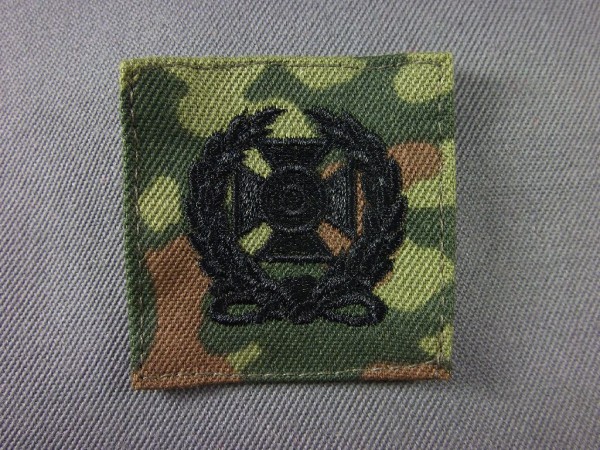 Expert, schwarz maschinengestickt auf Flecktarn