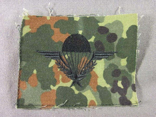 Fallschirmspringerabzeichen FR schwarz auf Flecktarn maschinengestickt, mit Stern